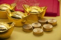 Chinese New Year packets with Chinese Gold Ingots and gold coins on yellow background. Festive season concept.