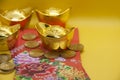 Chinese New Year packets with Chinese Gold Ingots and coins on yellow background. Chinese New Year celebration.