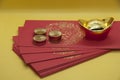 Chinese New Year packets with Gold Ingots and coins on yellow background. Chinese New Year concept.