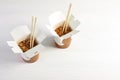 Chinese noodles in paper box on white wooden table, space for text. Royalty Free Stock Photo