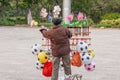 Chinese old man street vendor seller ball and other toys in the Public garden, Nansa, Yunnan, China. Football concept Royalty Free Stock Photo