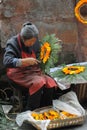 Chinese old woman wreathed flowers into a garland