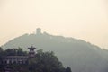 Chinese pagpda on a green hill and silhouette of another pagoda Royalty Free Stock Photo