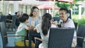 Asian family smiling, eating & drinking outdoor at streetside table Royalty Free Stock Photo