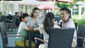 Asian family smiling, eating & drinking outdoor at streetside table Royalty Free Stock Photo