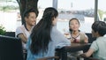 Asian family smiling, eating & drinking outdoor at streetside table Royalty Free Stock Photo