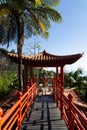 Chinese pavilion and bridge surrounded by wild nature, palm tree and tropical plants in an exotic garden. Royalty Free Stock Photo