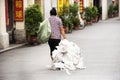 Chinese people old women dragging fertilizer sack on Paifang Street go to house in old town and ancient city center of Chaozhou