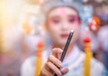 Chinese person in folk costume holding smartphone