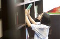 Chinese Portrait of young beautiful woman reaching for a library book In Bookstore