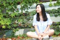 Chinese Portrait of young beautiful woman sit to wall in park Royalty Free Stock Photo