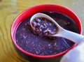 Chinese purple rice congee in a red bowl