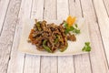 Chinese recipe of fried caramelized beef strips with fried red and green peppers and sesame seeds Royalty Free Stock Photo