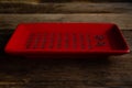 Chinese red, square crockery with hieroglyphs on an old wooden table.