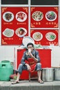 Chinese restaurant owner takes a break outside, Kunming, China