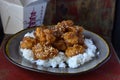 Chinese Sesame chicken on white rice on plate