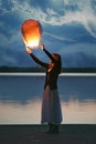 Chinese sky lantern and young woman at dusk Royalty Free Stock Photo