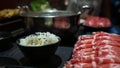 Chinese spicy hotpot soup. Plates of raw meat slides and rice bowl at restaurant Royalty Free Stock Photo