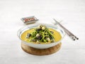 Chinese Spinach with Salted Eggs and Century Eggs in a dish with chopsticks side view on grey background