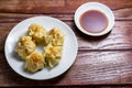 Chinese Steamed Dumpling, Shumai on white dish served with soy sauce on wooden table. Delicious Dimsum pork Royalty Free Stock Photo