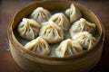 Chinese steamed dumplings in bamboo basket on wooden table.