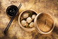 Chinese steamed dumplings in bamboo steamer with soy sauce and chopstick Royalty Free Stock Photo