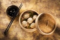 Chinese steamed dumplings in bamboo steamer with soy sauce and chopsticks Royalty Free Stock Photo