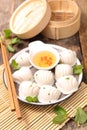 Chinese steamed dumplings dim sums in bamboo steamer and chopsticks