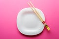 Chinese sticks white plate on a pink background