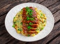 Chinese style Egg fried rice with sliced pork fillet on wooden table. Royalty Free Stock Photo