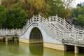 Chinese style pedestrian stone arch bridge over lake in park Royalty Free Stock Photo