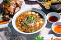 Chinese style soup; or braised fish maw in red gravy with eggs, mushroom, and bamboo shoot in white bowl. Braised Fish Maw in Red