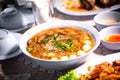 Chinese style soup or braised fish maw in red gravy with eggs, mushroom, and bamboo shoot in white bowl. Braised Fish Maw in Red G Royalty Free Stock Photo