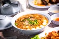 Chinese style soup or braised fish maw in red gravy with eggs, mushroom, and bamboo shoot in white bowl. Braised Fish Maw in Red G Royalty Free Stock Photo