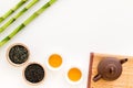 Chinese tea ceremony concept. Tea pot, tea cup, dry tea leaves, bamboo mat on white background top view copy space Royalty Free Stock Photo