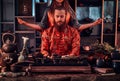 Chinese tea ceremony. Couple in oriental traditional clothes during a Chinese tea ceremony in the dark room with a Royalty Free Stock Photo