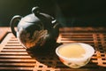 Chinese tea ceremony. Teapot and a cup of green puer tea on wooden tabl with small amount of vapour. Asian traditional culture. Royalty Free Stock Photo