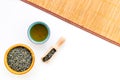 Chinese tea concept. Tea ceremony. Dry tea leaves in bowl and wooden scoop near cup of tea on white background and Royalty Free Stock Photo