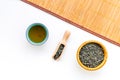 Chinese tea concept. Tea ceremony. Dry tea leaves in bowl and wooden scoop near cup of tea on white background and Royalty Free Stock Photo