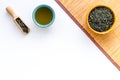 Chinese tea concept. Tea ceremony. Dry tea leaves in bowl and wooden scoop near cup of tea on white background and Royalty Free Stock Photo