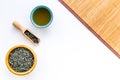 Chinese tea concept. Tea ceremony. Dry tea leaves in bowl and wooden scoop near cup of tea on white background and Royalty Free Stock Photo