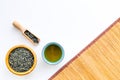 Chinese tea concept. Tea ceremony. Dry tea leaves in bowl and wooden scoop near cup of tea on white background and Royalty Free Stock Photo