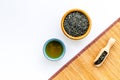 Chinese tea concept. Tea ceremony. Dry tea leaves in bowl and wooden scoop near cup of tea on white background and Royalty Free Stock Photo