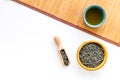 Chinese tea concept. Tea ceremony. Dry tea leaves in bowl and wooden scoop near cup of tea on white background and Royalty Free Stock Photo