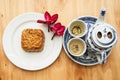 Chinese tea set with mooncake and red flowers in natural light