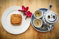 Chinese tea set with mooncake and red flowers in natural light