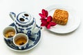 Chinese tea set with mooncake and red flowers in natural light