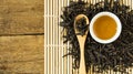 Chinese tea in white ceramic cup and dried tea leaves in wooden spoon Royalty Free Stock Photo