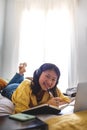 Chinese teen student doing homework at home. Female studying at home with laptop looking at camera. Vertical. Royalty Free Stock Photo