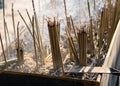 Chinese temple censers are filled with burning incense and surrounded by smoke.